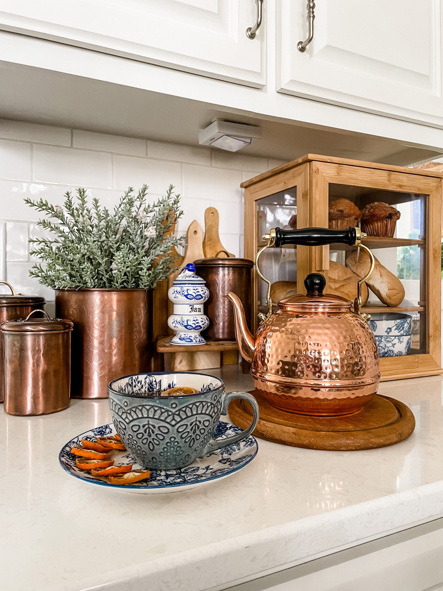 Classic copper tea kettle compliments vintage inspired blue and white dishes.