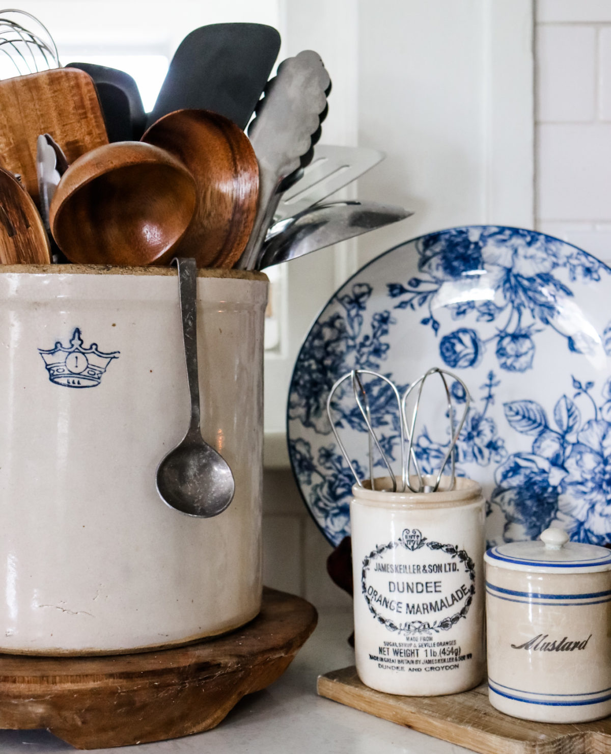 Vintage crock and marmalade jar are stylish organization options in a kitchen.